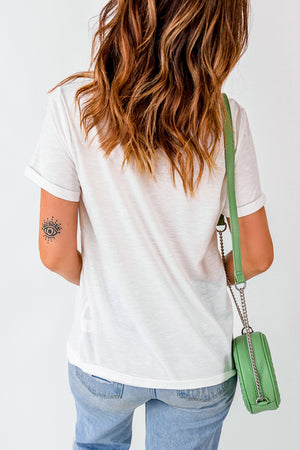 White casual t-shirt with cuffed sleeves, paired with light wash jeans and a green crossbody bag.