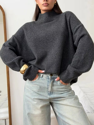 Relaxed mock neck sweater in dark gray acrylic blend with dropped shoulders and cuffed sleeves.