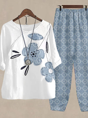 White floral print half sleeve top with blue floral appliques and matching patterned pants.