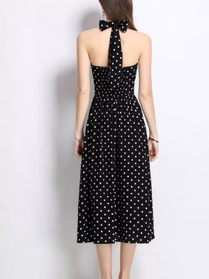Black polka dot halter midi dress with a bow detail at the neck.