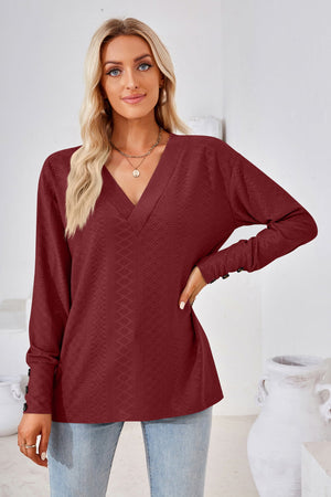 Burgundy textured V-neck blouse with button cuff long sleeves.