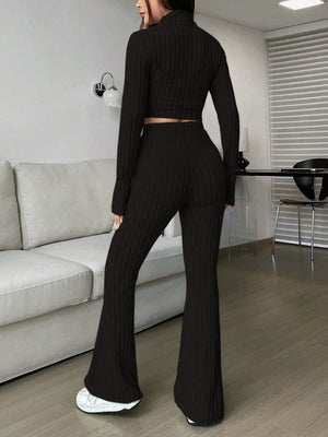 Black ribbed knit flare co-ord set with a cropped long sleeve top and high waisted flared pants.