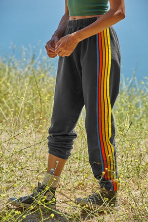 Gray track pants with rainbow stripe detail on the side