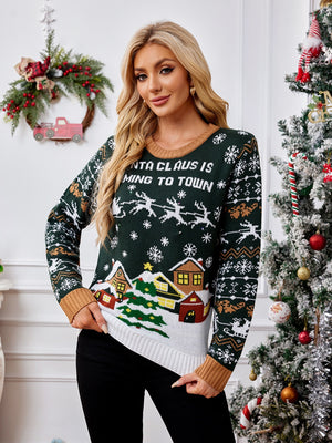 Festive graphic knit sweater in black forest with Santa Claus text and winter village scene.