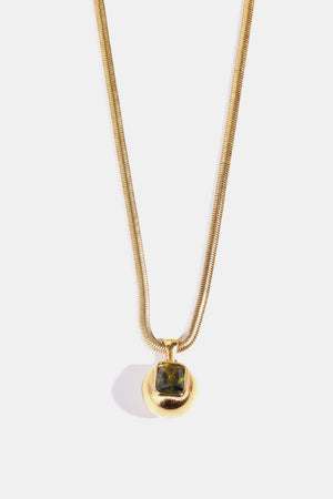 Gold necklace with orb pendant and green square stone
