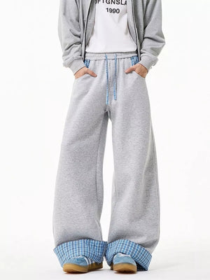 Gray wide-leg sweatpants with drawstring and blue plaid cuffs.