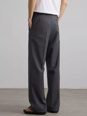 Grey pleated wide-leg trousers with a relaxed fit, shown from the back.