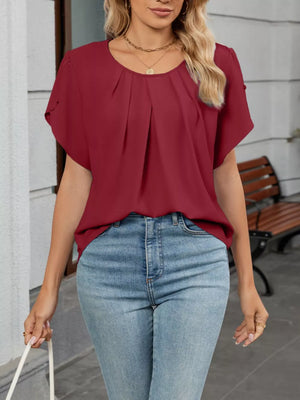 Sophisticated pleated short sleeve blouse in wine red polyester, with a round neckline.