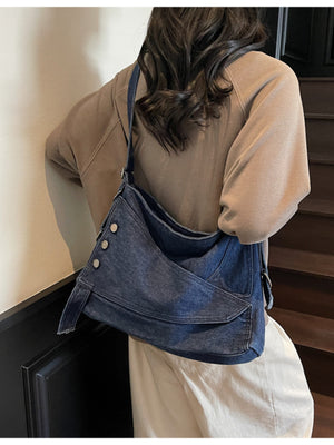 Relaxed denim crossbody bag with button accents and adjustable strap.