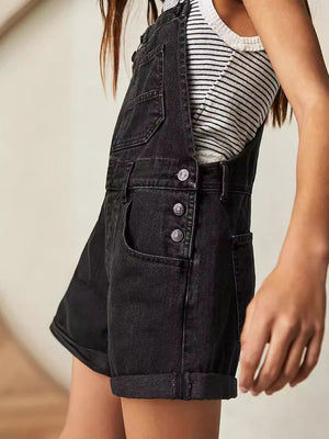 Black denim short overalls with rolled hems and button closures.