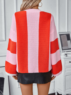 Colorblock stripe knit sweater in pink and orange with a waffle knit texture and long sleeves.