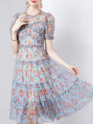 Light blue floral print tiered midi dress with ruffled details and short sleeves.