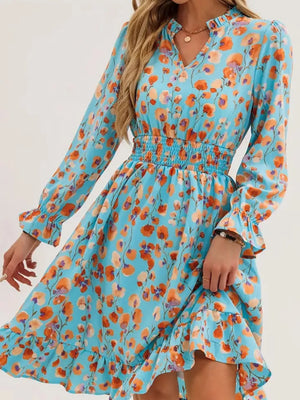 Pastel blue floral dress with smocked waist, ruffled cuffs, and V-neck.