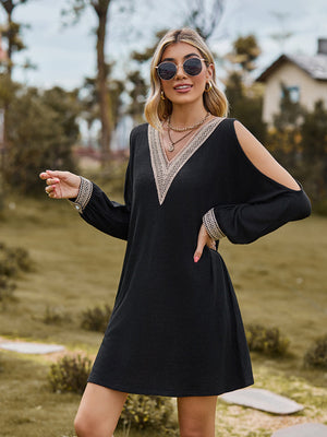 Black cold shoulder mini dress with lace trim V-neck and cuffs.