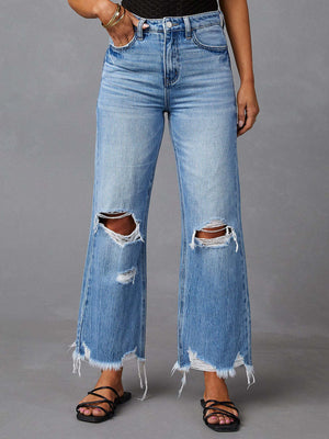 Light blue distressed flare jeans with raw hemline and ripped knees.