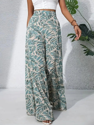 Palazzo trousers in 100% polyester with a tropical leaf print in green and beige.