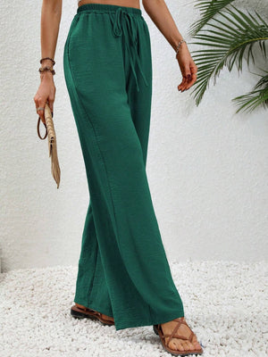 Dark green textured palazzo trousers with drawstring waist and wide legs.