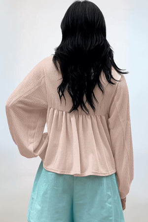 Beige textured blouse with gathered yoke and balloon sleeves.