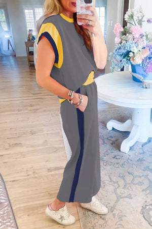 Gray two-piece set with yellow and navy trim, wide leg pants, and short sleeve top.