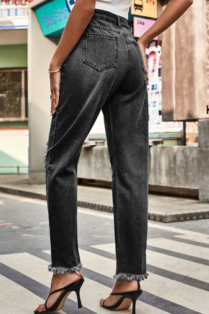 Dark wash distressed hem straight leg jeans with frayed cuffs.