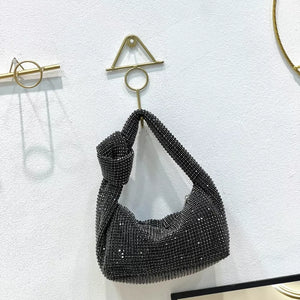 Black rhinestone crescent tote bag with knotted handle.
