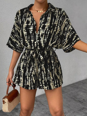 Black and white striped belted romper with collared neckline and button front.