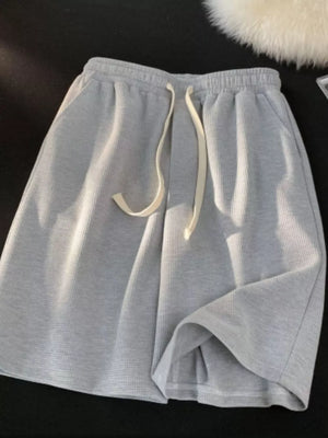 Grey waffle knit boxer shorts with a drawstring waist and pockets.