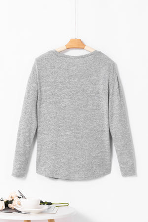 Dark gray slouchy knit top with side button detail and long sleeves.