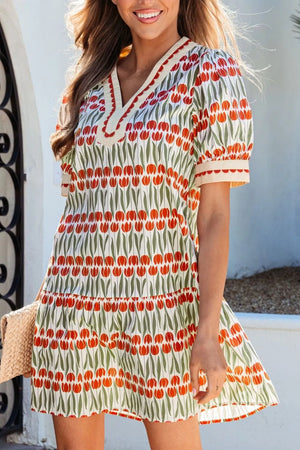 Cotton mini dress with red tulip print, V-neck, puff sleeves, and tiered skirt.