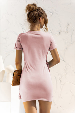 Blush pink jersey mini dress with short sleeves and knot-front detail.