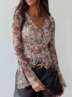 Charming floral print sheer blouse with tie neck and ruffled bell sleeves.