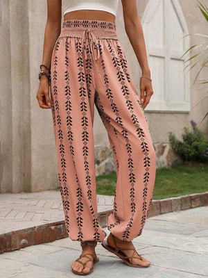 Burnt Coral leaf print gathered ankle trousers with drawstring waist and elastic cuffs.