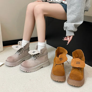 Fold-over suede platform boots in light gray and pumpkin with branding details.