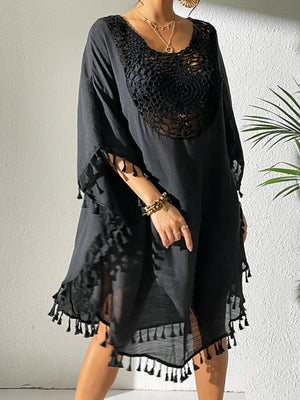 Black crochet yoke kaftan dress with tassel trim and wide sleeves.