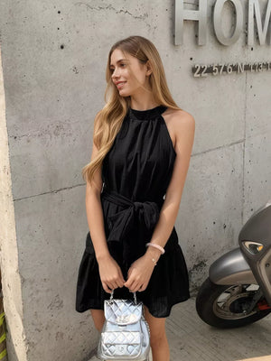 Black halter neck mini dress with tied waist and tiered skirt.