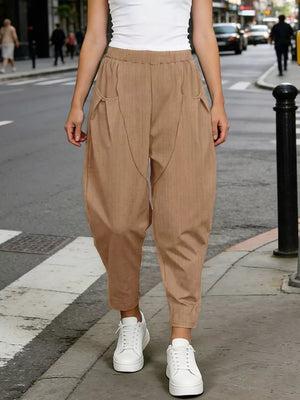 Camel harem joggers with pockets and a pinstripe detail, styled with white sneakers.