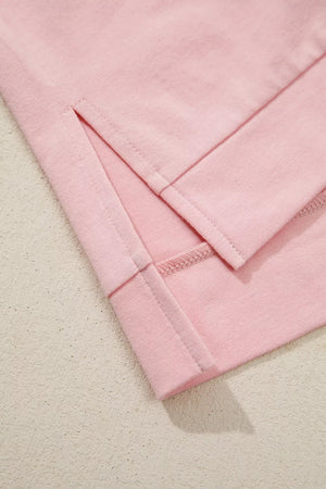 Pink cotton t-shirt with side slits and dimensional applique flower detail.