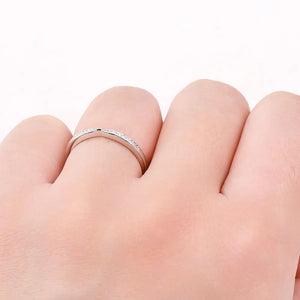 Silver moissanite chevron contour band ring with pavé stones.