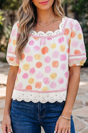 White polyester blouse with pink, orange, and yellow polka dots, puff sleeves, and lace trim.