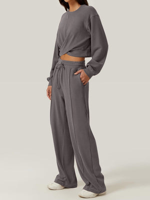 Dark gray knit lounge set with cross-front crop top and wide-leg drawstring pants.