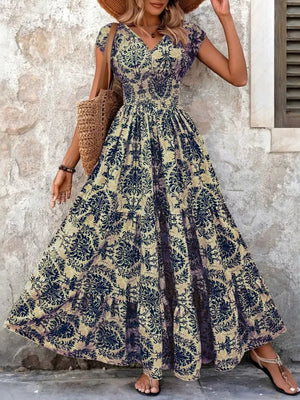 Maxi dress with smocked bodice, V-neck, short sleeves, and tiered skirt in a dark blue damask print.