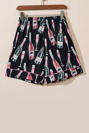 Black silk pajama shorts with champagne print and pink piping.