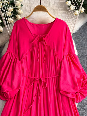 Fuchsia pink polyester maxi dress with balloon sleeves and tie neckline.