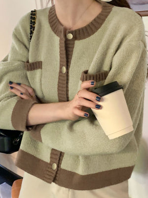 Green acrylic button up cardigan with contrast trim and pockets.