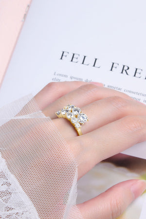 Gold cascading cluster diamond ring with clear stones on a hand.