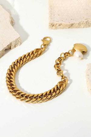 Gold chain bracelet with a shell charm and pearl detail
