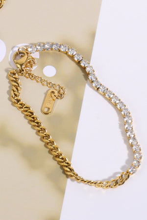 Gold dual-chain bracelet with a line of clear cubic zirconia stones and a cuban link chain.