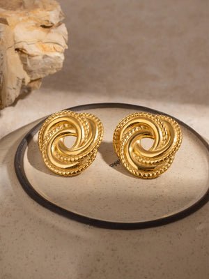 Gold swirl knot stud earrings with textured rope edge detail.