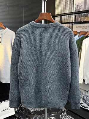 Plus-size gray ribbed knit sweater with button detail on the neckline.