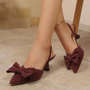Chic bow-embellished kitten heel pumps in red with slingback strap and pointed toe.